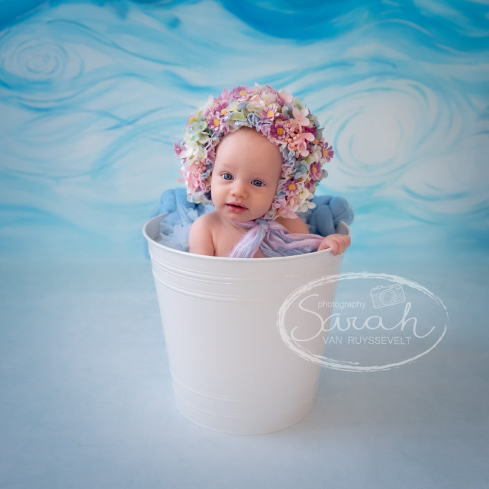 Sitter meisje, baby, 5 maand, babyportret met flowerbonnet, thema achtergrond, Sarah Van Ruyssevelt Photography