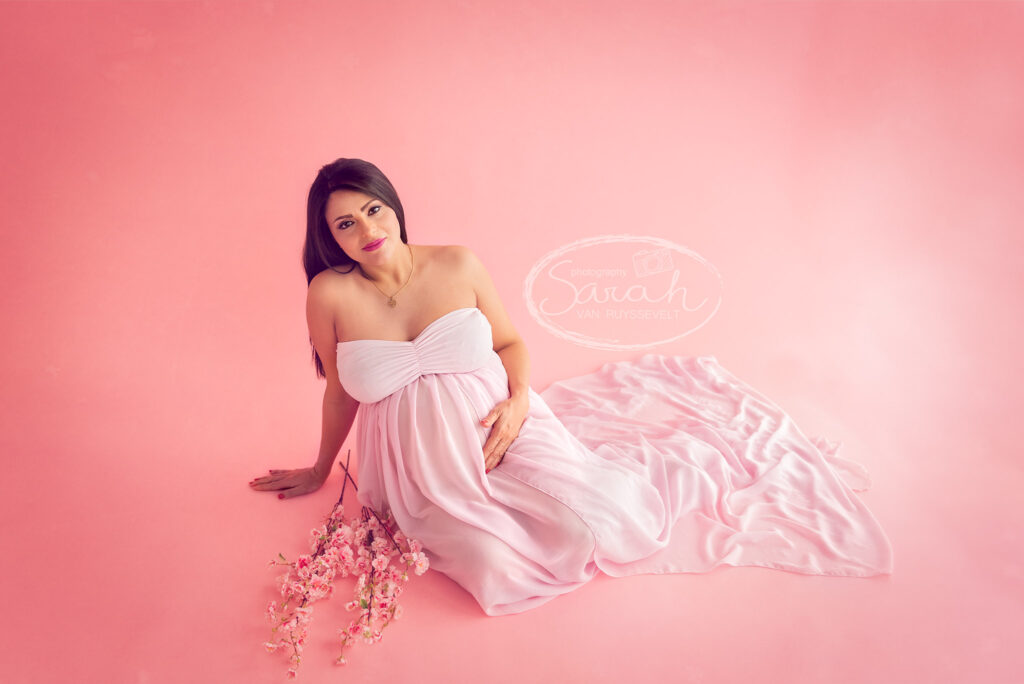 Zwanger in de studio, roze setting, bolle buik